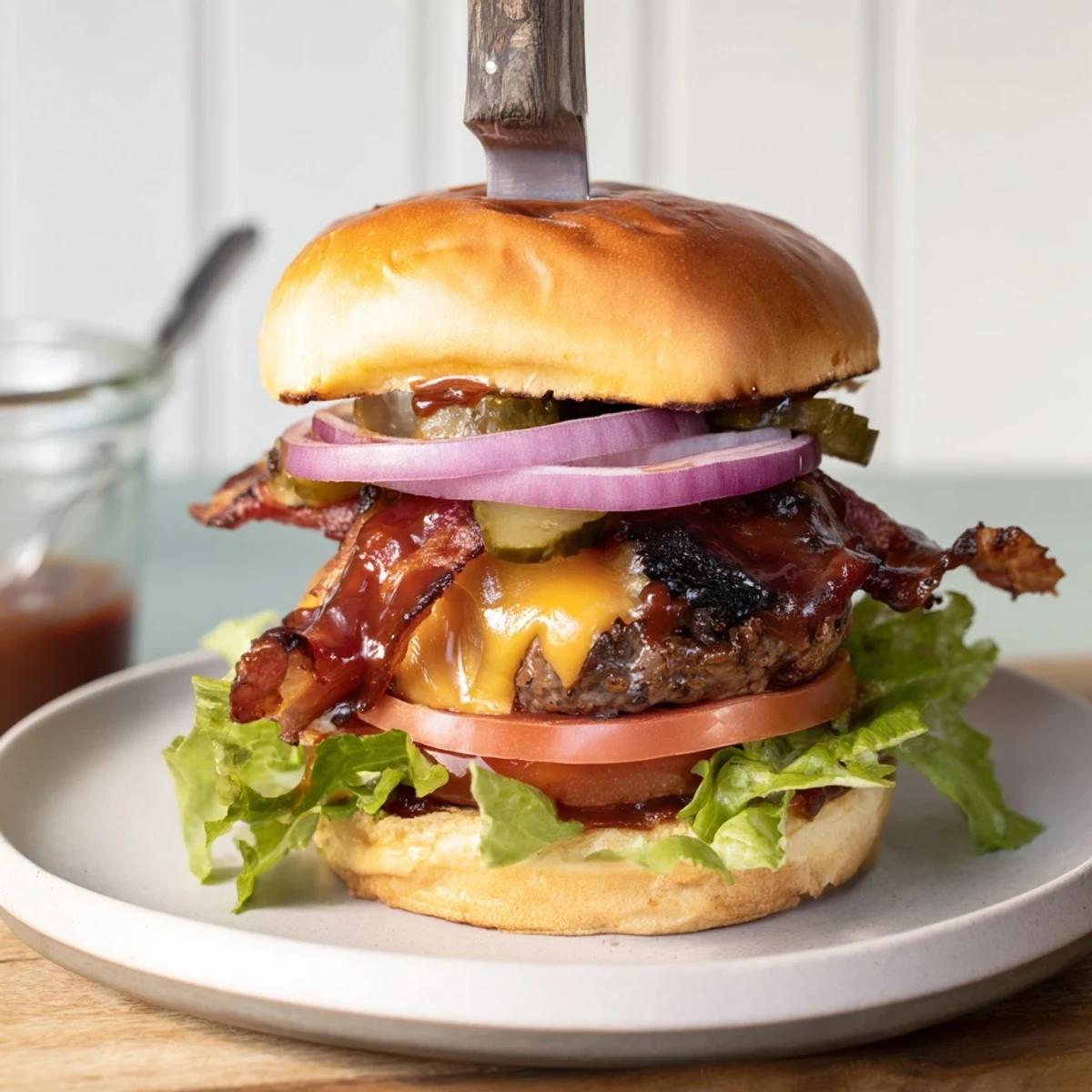 Mouthwatering BBQ Bacon Cheddar Burgers drizzled with tangy sauce and juicy beef.