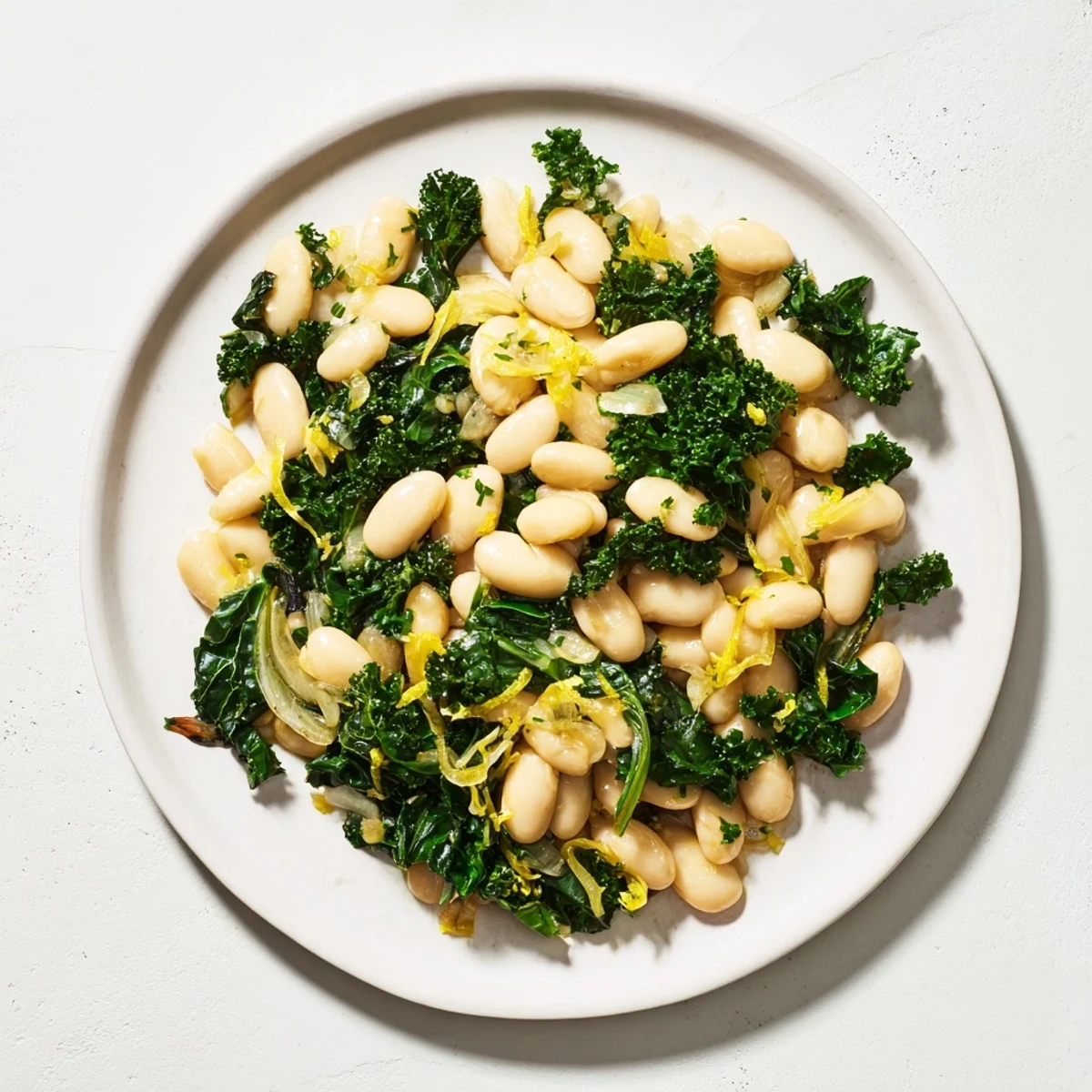 A beautiful, warm serving of Garlicky Beans with Winter Greens, drizzled with olive oil, ready for a delicious meal.