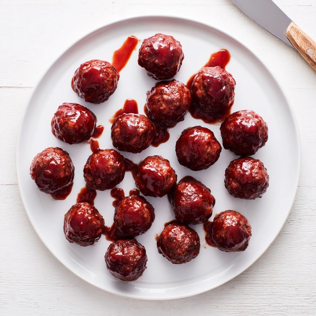 Appetizing cherry-glazed meatballs, shimmering with sweet, glossy sauce, ready to serve as a party appetizer.