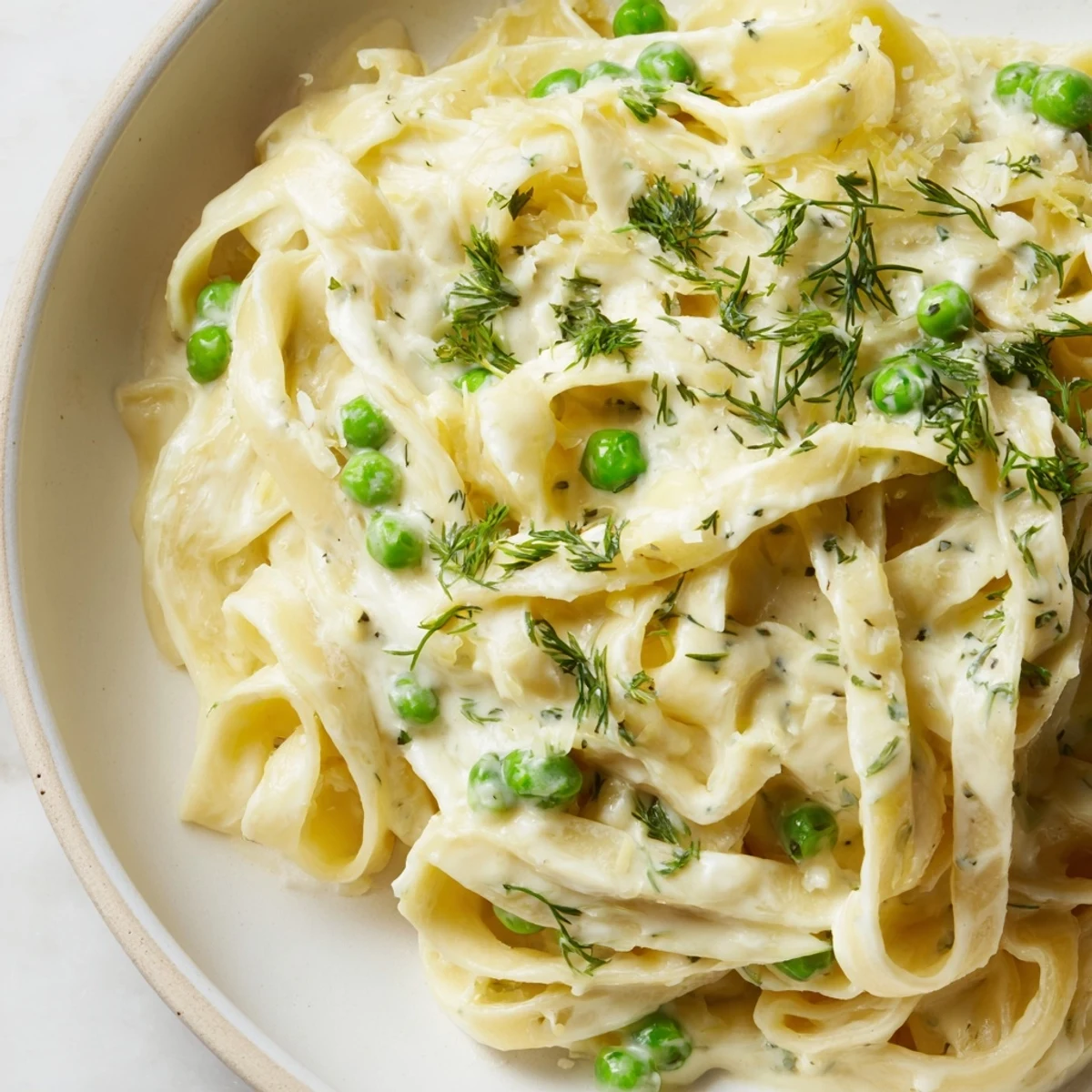 Creamy Dill Pasta swirled with fettuccine, bright lemon, and fresh dill, ready to eat.
