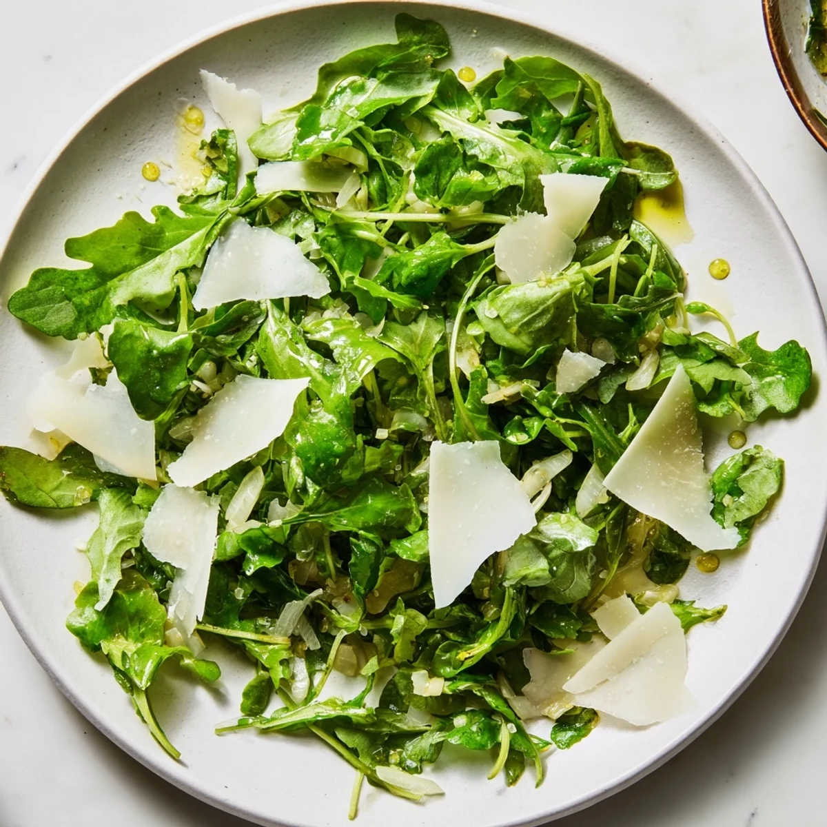 Fresh arugula salad with lemon dressing, Parmesan shavings, and a bright, citrusy aroma.