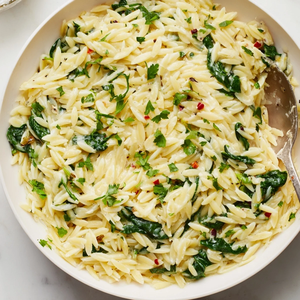 A close-up of One-Pot Creamy Orzo: a bubbling pot of orzo pasta with a creamy sauce.