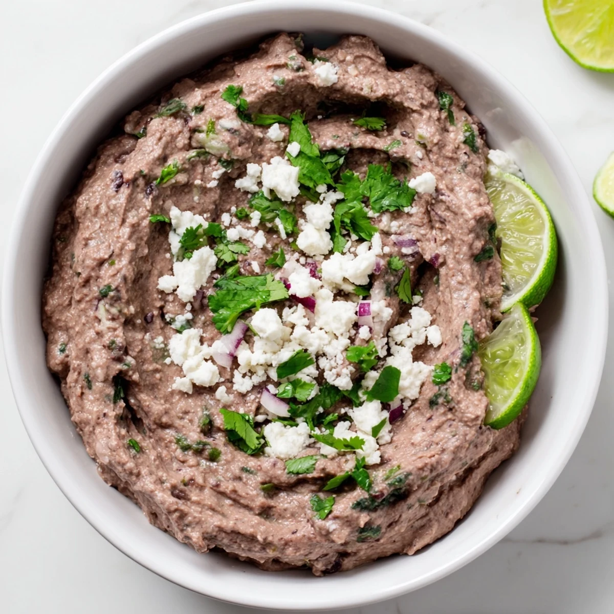 Creamy Spicy Black Bean Dip served with crunchy tortilla chips and colorful vegetable sticks, perfect for game day snacks or taco night spreads.
