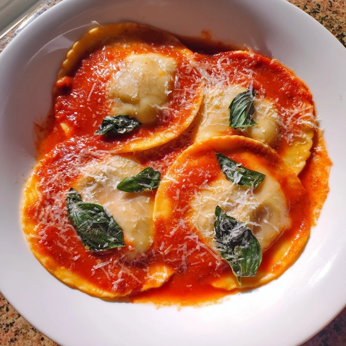 Spinach Ricotta Ravioli topped with marinara and Parmesan, served on a white plate for a cozy Italian dinner.