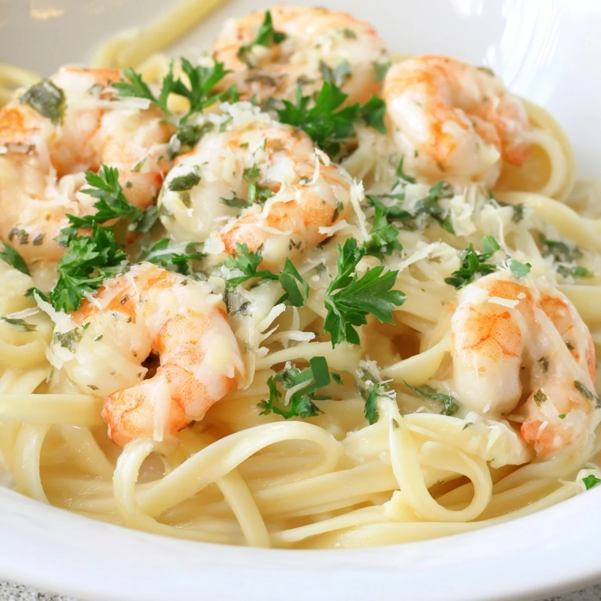 A close-up of Creamy Garlic Shrimp Pasta in a skillet, steam rising from the rich Parmesan sauce and bright red pepper flakes.