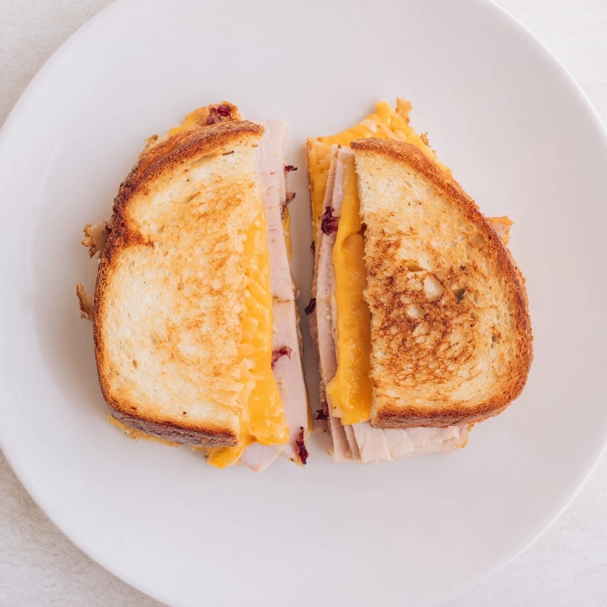 Sizzling Smoked Turkey Grilled Cheese cooking in a skillet, with buttered sourdough slices crisping to a perfect golden brown.