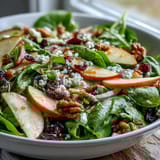 Freshly tossed Mixed Greens and Apple Bowl with crisp apple slices, red onion, and dried cranberries, served as a refreshing salad for a light lunch.