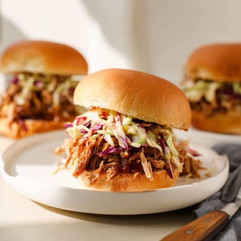 Tender smoked pulled pork sliders topped with crisp coleslaw for flavorful bites.  