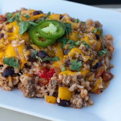 Warm, bubbling Tex-Mex Beef & Rice Casserole, topped with melted cheese, offers a comforting, savory meal.