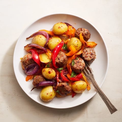 Sheet-Pan Sausage with Peppers showcases sizzling sausages and beautifully roasted vegetables for dinner.