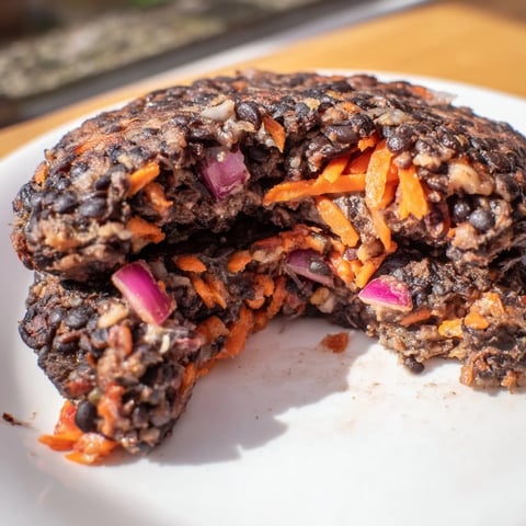 Golden, crispy black bean burgers on a toasted bun, perfect for a summer cookout meal.