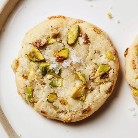Golden, flaky Salted Pistachio Slice & Bake Shortbread cookies, perfectly seasoned with sea salt crystals.