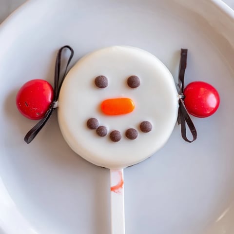 Budget-Friendly Oreo Snowman Pops: adorable chocolate-covered snowmen treats perfect for festive winter celebrations and kids.