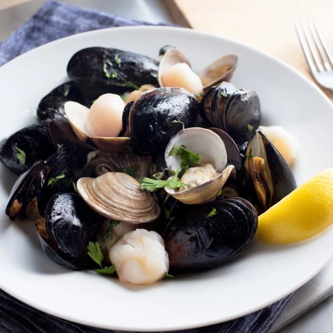 Steaming Shellfish & Seafood Medley, brimming with plump shrimp, clams, and mussels in a flavorful broth.