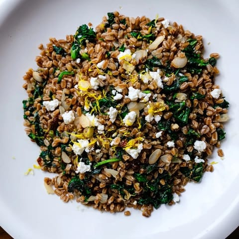 A visual of Warm Farro & Greens Pilaf, featuring fluffy farro with spinach and crunchy toasted almonds.