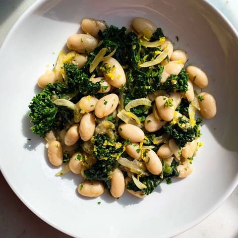 Close-up of vibrant Garlicky Beans with Winter Greens, showcasing tender greens and creamy beans, seasoned perfectly.