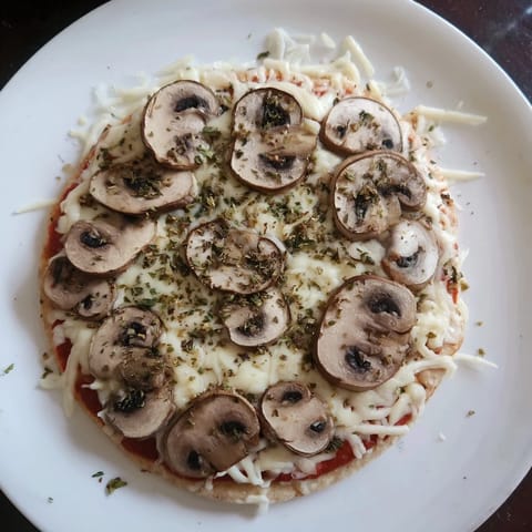 A close-up of a delightful upgraded frozen pizza with melted cheese and fresh herbs, ready to eat.