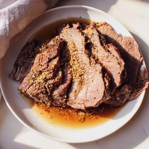Fork-tender Budget Holiday Chuck Roast, ready to serve, with flavorful pan juices perfect for smothering potatoes.