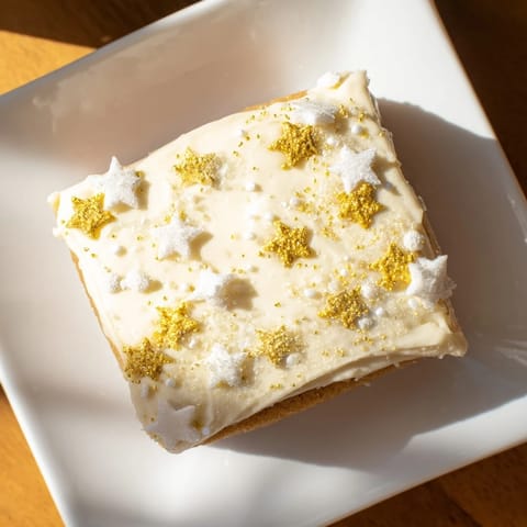 Golden, buttery Twinkle Twinkle Star Dessert Bars topped with vanilla frosting and twinkling sprinkles.