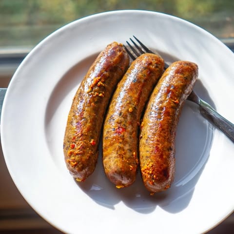 Close-up of freshly cooked Tunisian Merguez sausage, showcasing the spicy, savory, mouthwatering textures.
