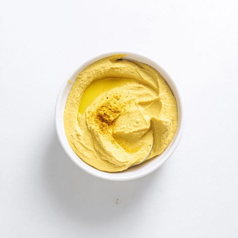 Creamy chickpea curry paste served with naan bread and fresh vegetable sticks for dipping.