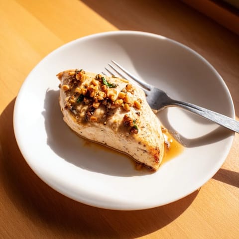 A close-up of juicy Honey Dijon Chicken Skillet garnished with parsley, served alongside fluffy white rice on a rustic plate.