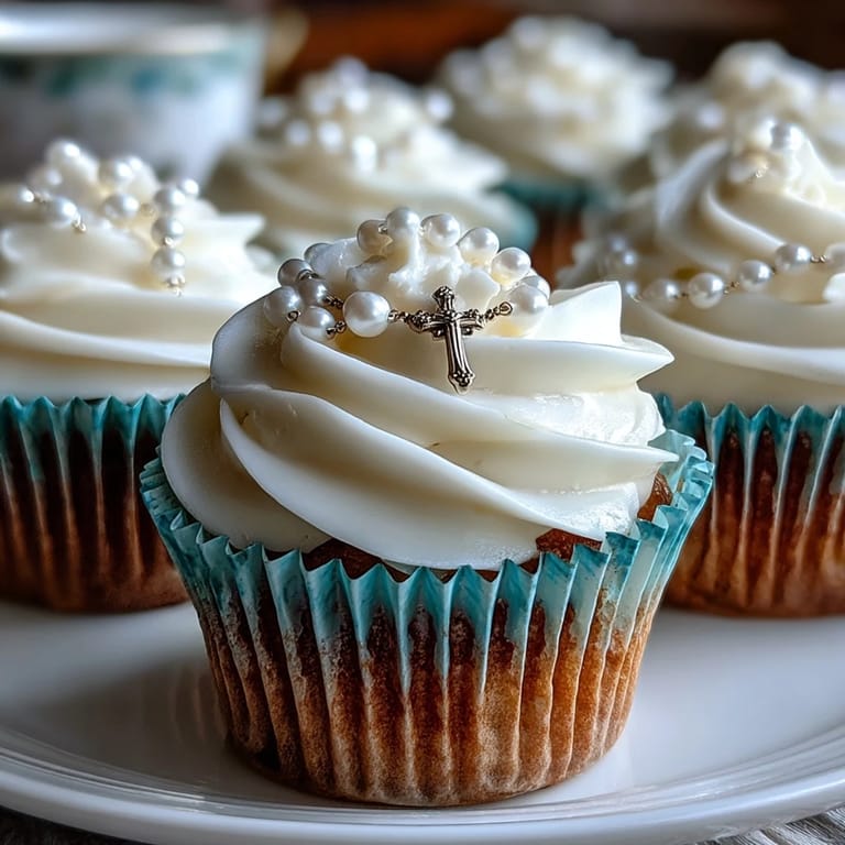 Delicate First Communion cupcakes topped with creamy frosting and fondant rosary details, ideal for honoring this sacred milestone.