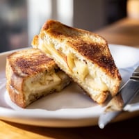 The finished Smoked Gouda & Apple Grilled Cheese, featuring melted cheese and crisp apple slices on golden-brown sourdough bread.  