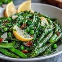 Fresh shaved asparagus and pea salad with lemon dressing, a vibrant spring dish bursting with crisp textures and bright citrus flavors.