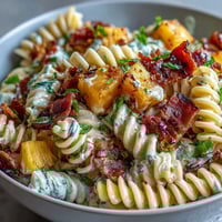 Vibrant Hawaiian pasta salad with ham, pineapple, and ranch dressing, packed with colorful veggies and creamy flavors.